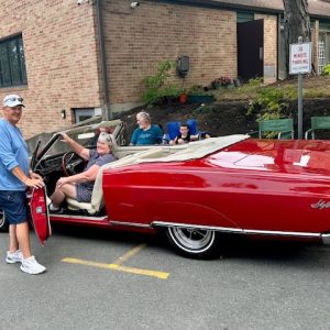 KATHY MURPHY TAKES THE WHEEL: Ms. Murphy learned how to drive in a car just like this. So generous Ray Willis put her behind the wheel of his 1967 Cherry red Buick Skylark for her to reminisce down memory lane. (Courtesy photo of Joanie Allbee)