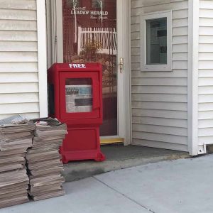 The Everett Leader Herald office on Church St., Everett and a pile of newspapers out front.
