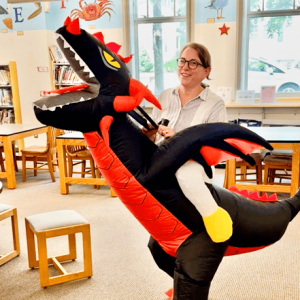 Librarian Kathryn Walton and “Smorg the Book Hoarder” prepare to visit the Belmonte STEAM Academy to encourage summer reading. (Courtesy Photo to The Saugus Advocate)