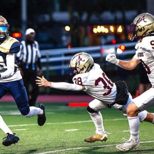 MAKING SOME SPACE: Malden High junior Felix Da Costa (26) looks for some room on a punt return.