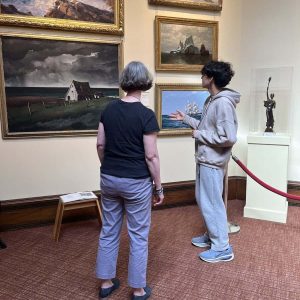 A Malden High School Teen is shown leading a tour in the Malden Public Library’s Art Gallery.