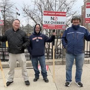 Representatives of “Keep Malden Affordable,” a group that has actively opposed the override ballot questions since their inception, were among the few sign holders for either side of the issue at the polls Tuesday. Here they appeared at the Beebe K-8 School polling place. (Advocate Photo)