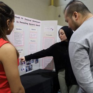 PCSS I 11th-graders Doha Marbouh (left), of Revere, and Sallam Ali (right), of Malden, present their Science project, “The Effectiveness of Natural vs. Chemical Disinfectants In Preventing Bacterial Growth,” to a judge. (Courtesy photo)