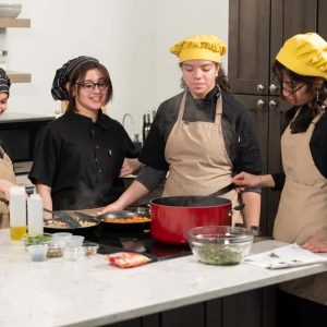 Students from the Northeast Metro Tech Culinary Arts program prepare a creamy chicken pesto orzo dish during the filming of their new program, “Northeast Cooks,” at the RevereTV station. Pictured from left to right: Yanisa Mieses, 18, Natalie Velasco Henriquez, 18, Alaxandra Mencia, 18, and Andreas Jaramillo, 16. (Courtesy Northeast Metro Tech)