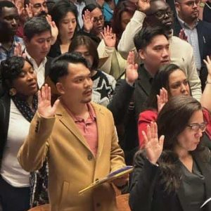 The most important step: New citizens recite the Oath of Allegiance at formal U.S Naturalization exercise at MHS’ Jenkins Auditorium last week.