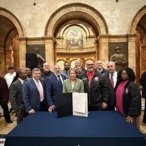 Legislators, Governor Maura Healey and Boston Carmen’s Union Local 589 members with the signed legislation.