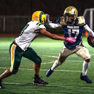 Talk to the Hand! Malden High running back Jayden McGuffie (17) goes all “Talk to the Hand” with this stiff arm move to break free from Lynn Classical’s Yonari Ruiz (18) in the Tornados’ Homecoming Game at Macdonald Stadium on October 3. Malden made a tremendous comeback in this game, trailing 24-6 in the second half and then falling in the end, 30-28. See the story and more photos inside today’s edition. (Advocate Photos/Henry Huang)