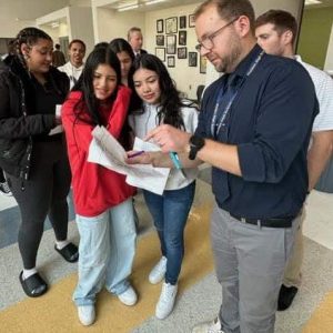 POINTING OUT THE PROTOCOL: Malden High Social Studies Department Teacher-Leader Kurtis Scheer pointed out how to mark the ballot to some novice student voters.