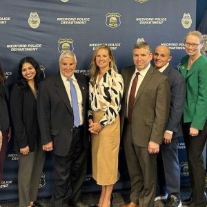 Senator Sal DiDomenico (in maroon tie) at the event with Portal to Hope’s Founder, Deb Fallon (far left), as well as legislators, advocates and Medford Police.