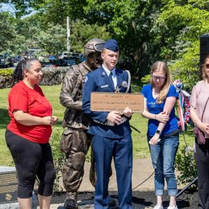 HONORING A HERO: Brent Garvin, holding his father's Gold Star Bronze Plaque, with his aunt, Catherine Price and mother, Sarah Clermont along with Councilor Peg Crowe and former US Marine Andrew Roberson during the plaque dedication for Brent's father, US Marine Lance Corporal Ed Garvin who was KIA in Iraq.
