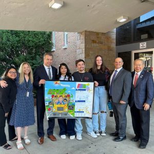Students presented the Department of Elementary and Secondary Education Commissioner, Pedro Martinez, with a Massachusetts Association of School Committees poster as he welcomed them to school. From left: Building Committee member Blanca Gacharna, Assistant Superintendent Tracey O’Brien, Commissioner Martinez, Rosemary Brady of Reading, Trevor Burt of Melrose, Superintendent David DiBarri and State Representative Donald Wong. (Photo Courtesy Northeast Metro Tech)