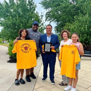 Mayor Carlo DeMaria was honored to receive a plaque, T-shirts and bracelets from Jay Holt, his wife Linda and their granddaughters Jae’lei and Skylar in recognition of his support for their annual Cornhole for Cancer tournament. Each year, community members rally together in not only support of Jay, who was diagnosed with multiple myeloma, but for everyone who has been affected by cancer in any way. Mayor DeMaria would like to thank the Holt family for presenting him with these mementos and is proud to assist with such an event.