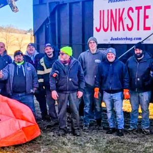 READY TO GO: A volunteer corps of citizens and town officials assisted by Leo Getz and his Junkster Bags crew and equipment cleaned up an abandoned homeless camp in a wooded area behind the Target Saugus store parking lot near Lynn Fells Parkway last Friday. (Courtesy photo to The Saugus Advocate)