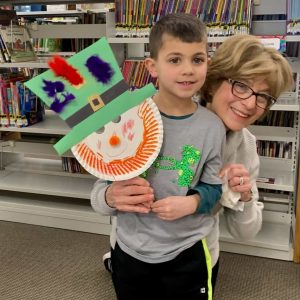 ST. PATRICK’S DAY ART: Lorenzo Dellheim, 5, of Saugus, had fun crafting a Leprechaun while attending a Creation Learning Station at the Saugus Public Library. Sharing a moment with the boy is Janice Nelson, a Saugus resident who led the program. She works at the Tower Day School in Lynnfield. (Courtesy Photo of Amy Melton, Head of Children’s Services at the Saugus Public Library)