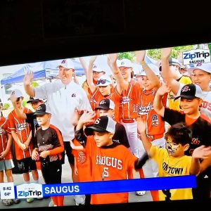 Saugus Little League President John Benoit and a group of players got to wave to people watching the Boston 25 News “Zip Trip” last Friday. (Saugus Advocate photo by Mark E. Vogler)