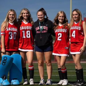 Saugus field hockey captains and coach, left to right, Jordyn Ripley-Deminski, Sydney Ferreira, Coach Julie Champigny, Audrey Comeau and Anna Enwright.
