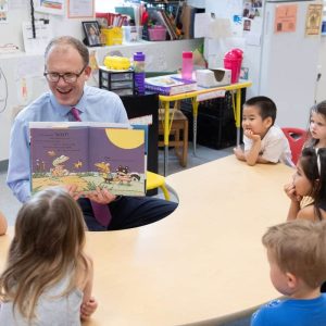 State Senator Jason Lewis reads a book to young students at a Malden public school.