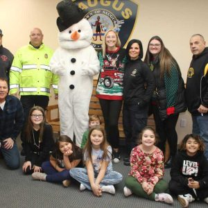 Shown from left to right: Back row: Firefighter Anthony Arone, Assistant Police Chief Ron Giorgetti, Frosty, Youth & Recreation Department Director Crystal Cakounes, Youth & Recreation Department Program Coordinator Emily Grant, Police Detective Stacey Forni and Sgt. Kevin Murphy; front row: Detective John Daigle, Belmonte STEAM Academy fourth-grader Layla Najem, Belmonte STEAM Academy second-grader Isabella Buttera, Veterans Memorial Elementary School kindergartener Brackett Marshall, Belmonte STEAM Academy fourth-grader Ava Najem, Veterans Memorial Elementary School first-grader Mila Murphy and Belmonte STEAM Academy fourth-grader Aaria Lenardis.