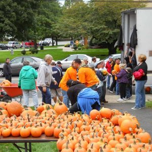 THE PUMPKIN BRIGADE: Volunteers from a previous year unloaded pumpkins at the First Congregational Church “Pumpkin Patch” in Saugus Center. Volunteers are needed again, on September 27, to help with this year’s unloading. (Courtesy photo to The Saugus Advocate)