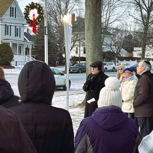 TWO FAITHS MEET: Retired Cliftondale Congregational Church Pastor Dr.  Robert Leroe talked to the crowd as he stood near the lit menorah celebrating Chanukah while a Christmas wreath hung on a light post a short distance away. (Courtesy photo of Joanie Allbee)