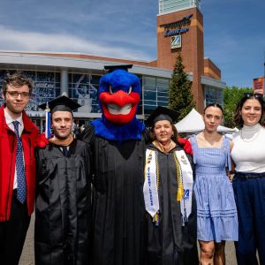 The UMass Lowell mascot, Rowdy the River Hawk, joined the Whitcomb family of Saugus at last Saturday’s commencement exercises. From left to right: Andrew ’24, ’25 (master’s degree); Bryce ’26; Maureen ’26; Collette ’23 and Diana Whitcomb ’23. (UMass Lowell courtesy photo by Henry Marte)
