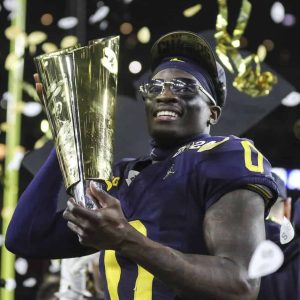 Michigan defensive back Mike Sainristil (0) of Everett proudly poses with the national championship trophy after the Wolverines defeated the Washington Huskies, 34-13 at NRG Stadium in Houston on Monday, Jan. 8. (Courtesy photo / Detroit Free Press / Junfu Han)