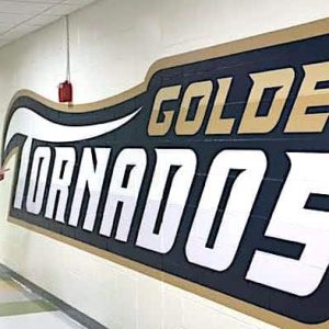 WALL-TO-WALL GOLDENS TORNADOS: Malden Public Schools Director of Physical Education and Athletics Charlie Conefrey shows off the new addition of wall art outside his office at Malden High School. (Courtesy/MPS Athletic Dept.)