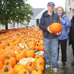 WAVE OF ORANGE: Shown from left to right: Pumpkin Patch Coordinator Carl Spencer, Assistant Coordinator Karen Spencer and volunteer Linda Anderson, all of Saugus – who attend church here – sold pumpkins in the rain on Saturday.