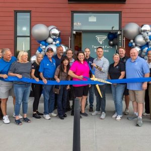 Mayor Patrick Keefe, Jr. is shown cutting the ribbon with local city and state officials as well as HYM VP Madeline Fitzgerald, State Representative Jessica Giannino and Twisted Fate Brewing’s ownership team of Dave Pinette, Erica Tritta, Kim McNamara and Bill McNamara. (Courtesy photo)