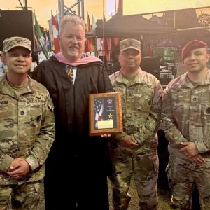 Everett High School Music Department Head and longtime Marching Band Director Eugene O'Brien, second, left, receives the 2024-25 U.S. Army Award of Excellence at Everett Memorial Stadium during graduation in June. Posing with O’Brien and representing the Army during the ceremony are, from left, Sergeant First Class Baniaga, Sergeant First Class Pascal and Staff Sgt Lopez. (Courtesy photo)