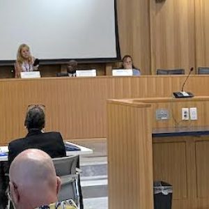 City officials are at the City Council Chambers dais to hear testimony from candidate Jeffrey Donahue (seated at right of podium) with a ballot challenge objection on incumbent Ward 4 School Committee member/candidate Dawn Macklin (seated at left of podium). (Courtesy Photo)