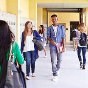 Group Of High School Students Walking Along Hallway Talking